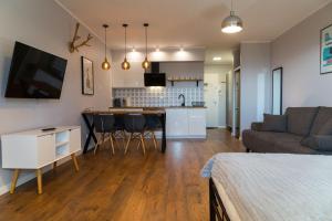 un soggiorno e una cucina con divano e tavolo di VacationClub – Bukowa 17A Apartament E.1 a Wisła