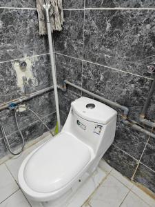 a bathroom with a white toilet in a wall at شقة مفرشة رقم 3 تبعد ٣ كم عن الحرم النبوي الشريف in Al Madinah