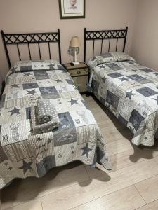 ein Schlafzimmer mit 2 Betten und einem Tisch mit einer Lampe in der Unterkunft HOTEL RURAL LOS FAROLES in Huérmeces