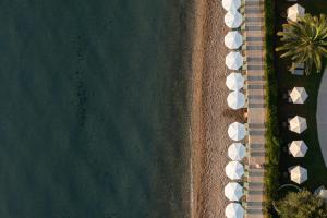 an overhead view of a beach with white umbrellas at Elea Beach Hotel in Dassia