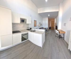a kitchen with white cabinets and a wooden floor at DS Precioso LOFT a estrenar in Córdoba