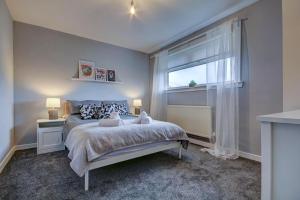 a bedroom with a bed and a large window at Ravenscroft - Coorie Doon in Irvine