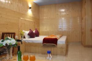 a bedroom with a bed in a wooden room at Guruchhaya hotel and cottages in Manāli