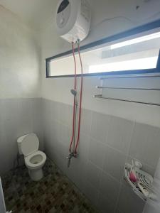 a bathroom with a toilet and a window at Jasmine 37 House 