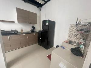 a kitchen with a black refrigerator and a sink at Jasmine 37 House 