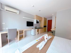 a room with a bed and a desk and a room with at Ahad Suite Aonang in Ban Khlong Haeng