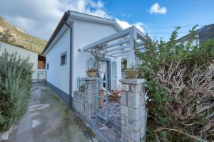 ein weißes Haus mit einem Tor und Pflanzen in der Unterkunft Casa Celeste - Goelba in Pomonte