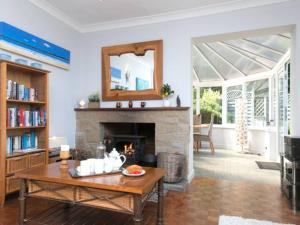 ein Wohnzimmer mit einem Kamin und einem Tisch in der Unterkunft Coastal Cottage with Stunning Views Pass the Keys in Llanddona
