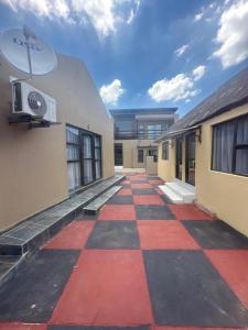 an empty courtyard of a building with a checkered floor at Sweet Nice Guest House in Ga-Rankuwa