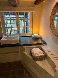 een badkamer met een wastafel en een aanrecht met een spiegel bij Luttik in Alkmaar