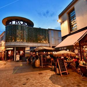 a building with people sitting at tables in front of it at ibis budget Cholet Centre in Cholet