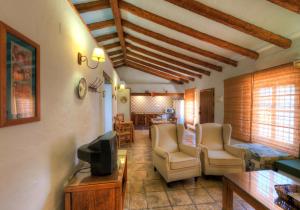 科尼爾－德拉弗龍特拉的住宿－Hacienda los Majadales，客厅配有椅子、电视和桌子