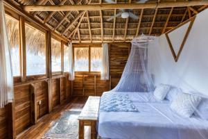 sypialnia z łóżkiem i drewnianym sufitem w obiekcie Still Salty Escape w mieście El Viejo