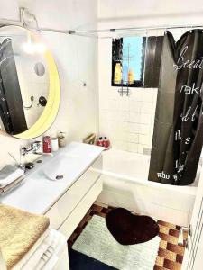 a white bathroom with a sink and a shower at כפר בלב העיר המקום ביותר בתל אביב in Tel Aviv