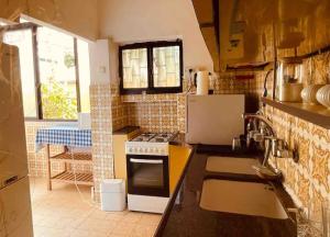 a kitchen with a sink and a stove top oven at כפר בלב העיר המקום ביותר בתל אביב in Tel Aviv