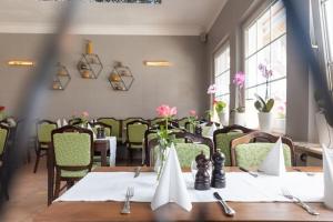a dining room with tables and chairs and windows at Ferienwohnung Bergwichtel Hahnenklee "super Aussicht" in Hahnenklee-Bockswiese