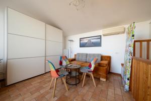 een woonkamer met een bank en stoelen bij ApartmentsGarda - Rosa Chiarè in Bardolino