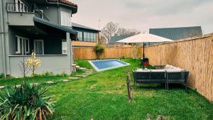 um quintal com uma piscina e um guarda-sol em MY RESORT PRİVE em Sapanca