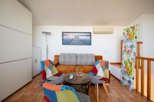 een woonkamer met een bank en een tafel en stoelen bij ApartmentsGarda - Rosa Chiarè in Bardolino