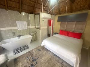 1 dormitorio con cama blanca, lavabo y bañera en Sweet Nice Guest House, en Ga-Rankuwa