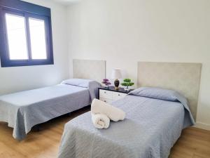 1 dormitorio con 2 camas y una toalla encima en Sea Views Villa Benalmádena ComoTuCasa, en Benalmádena