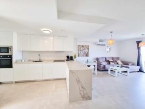 cocina y sala de estar con armarios blancos y sofá en Sea Views Villa Benalmádena ComoTuCasa en Benalmádena