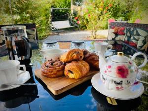 a table with a tray of pastries and tea pots at Maison Des Glycines in Droux