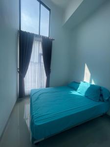 a bedroom with a blue bed with a window at Jasmine 37 House 
