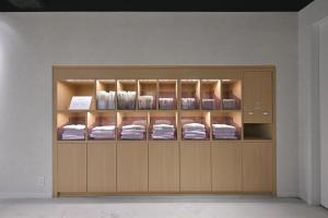 a wooden display cabinet with towels in it at Prince Smart Inn Hakata in Fukuoka