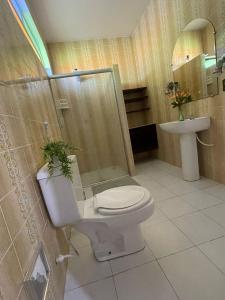 uma casa de banho com um WC, um chuveiro e um lavatório. em POUSADA FLOR DO IPÊ em Juazeiro do Norte