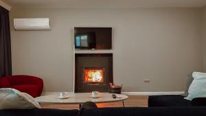 a living room with a fireplace with a tv above it at MY RESORT PRİVE in Sapanca