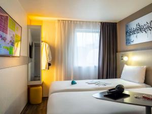 um quarto de hotel com duas camas e uma janela em ibis Styles Paris Bercy em Paris