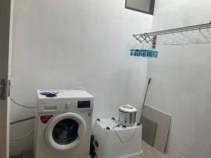 een wasmachine in een badkamer met een wasmachine bij Jasmine 37 House 