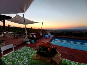 un jarrón de flores en una mesa junto a una piscina en La Terrazza di Cirico', en Carlentini