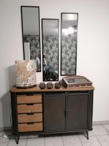 eine Kommode mit zwei Spiegeln und einem Waschbecken in der Unterkunft La maison Saint-Gervais in Falaise