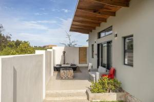 Casa bianca con patio e tavolo di Mountain and Sea Cottage a Hermanus