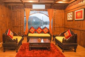 a living room with two chairs and a table at Ekta Houseboat Statue Of Unity Kevadia in Vadodara