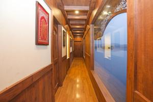 a hallway of a house with wood floors and an archway at Ekta Houseboat Statue Of Unity Kevadia in Vadodara