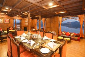 a dining room with a long table and chairs at Ekta Houseboat Statue Of Unity Kevadia in Vadodara