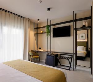 a bedroom with a bed and a desk and a tv at Nuvō Hotel Boutique in Oviedo