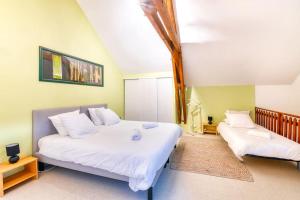 1 Schlafzimmer mit 2 Betten und weißer Bettwäsche in der Unterkunft Moulin de Neuville in Saint-Germain-de lʼHomel