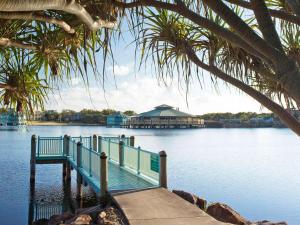 a dock with a house in the middle of the water at The Sebel Twin Waters in Twin Waters