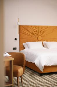 um quarto com uma cama, uma cadeira e uma secretária em Hotel Pietryna em Lódź