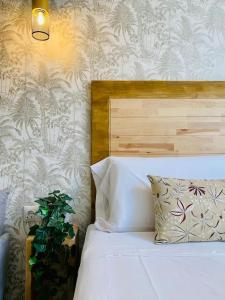 Un dormitorio con una cama blanca con una planta al lado en Cabanyal Room 3 - Small & Stylish by the Beach en Valencia