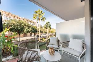 balcón con sillas y mesas y vistas a la calle en 215 Navi Golf, en La Cala de Mijas