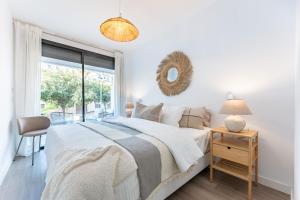 Un dormitorio blanco con una cama y una ventana. en 215 Navi Golf, en La Cala de Mijas 17 fotos más