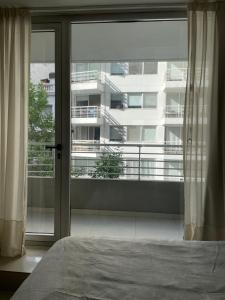 a bedroom with a large window with a view of a building at Excelente monoambiente en cañitas in Buenos Aires