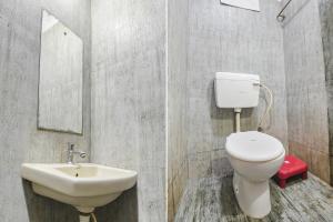 a bathroom with a sink and a toilet and a mirror at FabExpress IRAA Resort in Baga