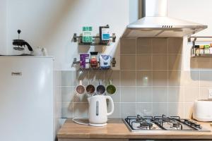 a kitchen with a stove with a kettle on a counter at Traditional stone cottage with sea views in Snowdonia National Park in Brynkir