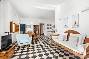 een woonkamer met een bank en een tv bij Villa Son Prats in Cala Santandria